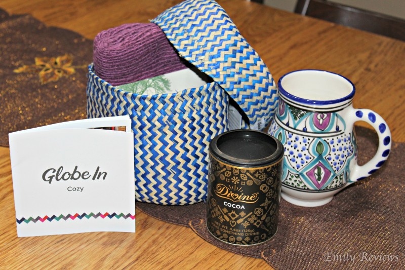 GlboeIn ~ The Cozy Basket Box ~ Greet crisp autumn mornings with a hot drink of choice in your colorful hand-painted mug from Tunisia. Feel snuggled all day long by wrapping up in your 100% cotton scarf from the mountains of Thailand. Sweeten up a chilly afternoon by mixing your Ghanaian cocoa powder with hot water or steamed milk—and a friend!