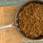 A pan of sloppy joe meat on a cutting board.