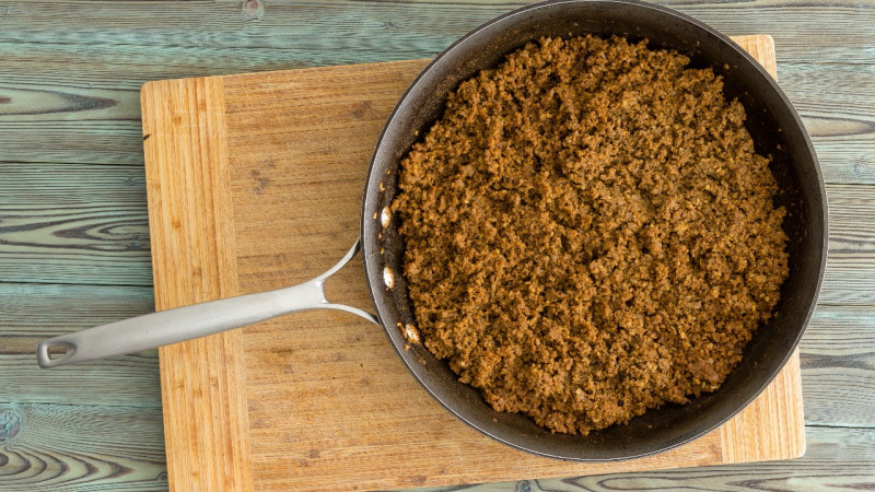 A pan of sloppy joe meat on a cutting board.