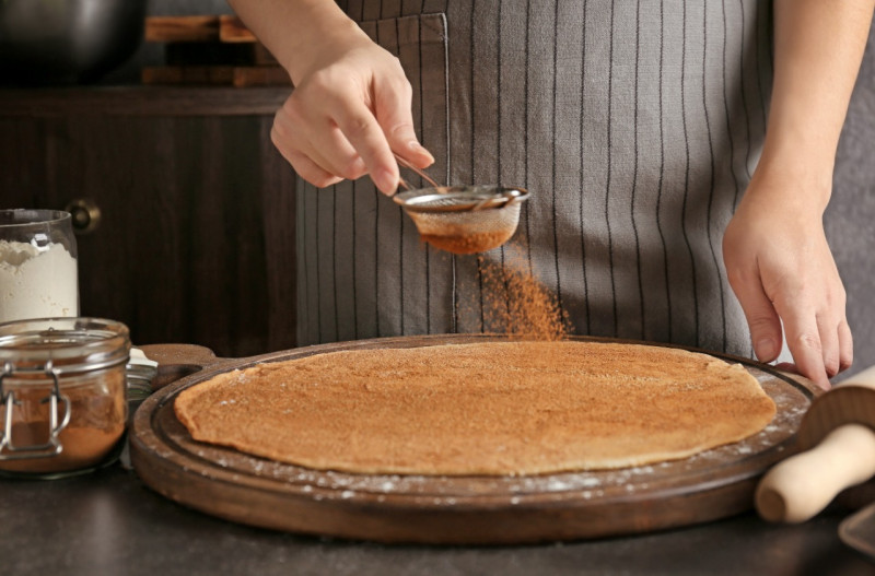 Woman rolling out cinnamon dough