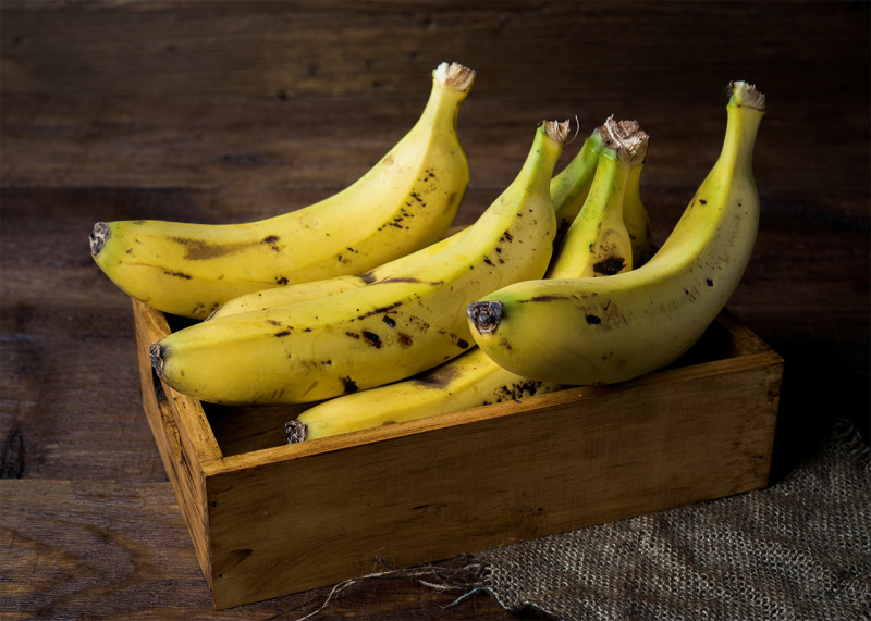 Ripe bananas in a wooden crate