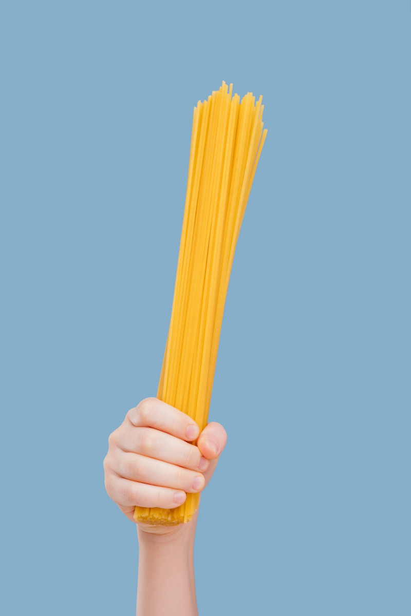 Child holding raw spaghetti