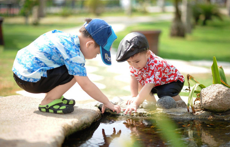 Boys playing by pond. Beat the Heat: Fun Games, Toys, Accessories, & Ideas for Hot Summer Days.